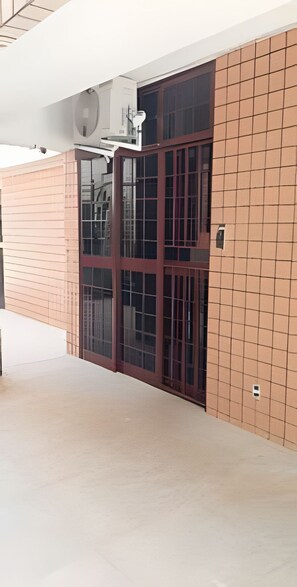 Ein Gebäude mit einer großen Glastür, einer Fliesenwand und einem flachen Dach.