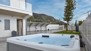 A modern outdoor hot tub area with a mountain backdrop. - Amazing home in Trabia (Trabia)