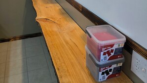 Una cocina con mostradores de madera, ollas colgantes, un extintor y una puerta.