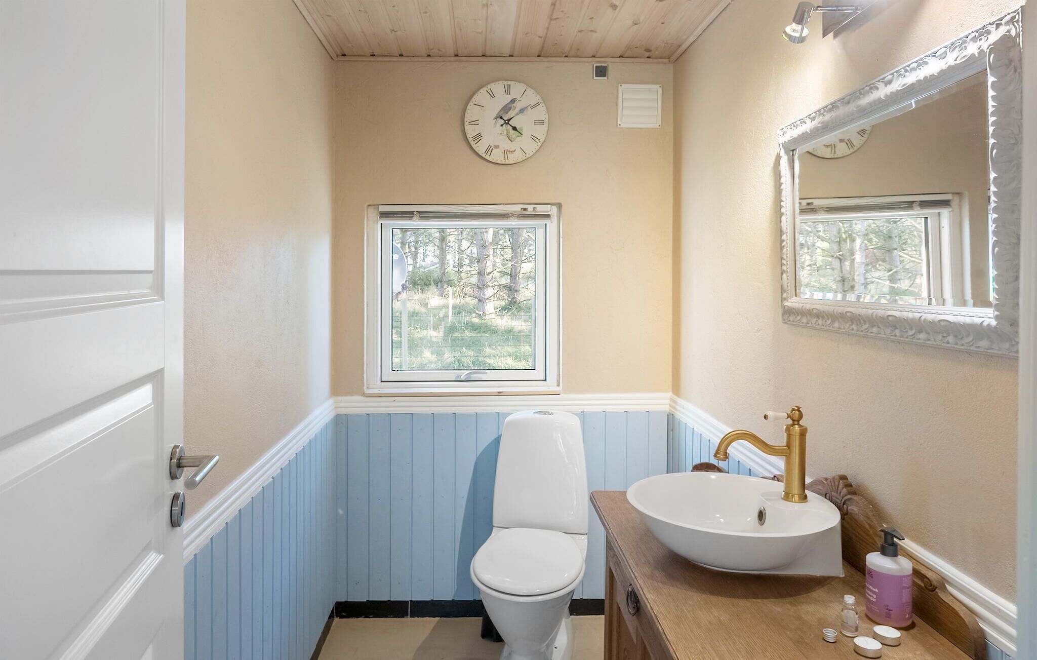 Une salle de bain avec des toilettes, un lavabo et une fenêtre.