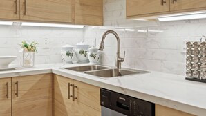 Een moderne keuken met houten kastjes, een RVS spoelbak en een vaatwasser.