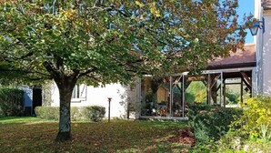 A house with a covered outdoor area, a tree, and a garden. - Gîtes de France® - Le Cocon (PRAYSSAC)
