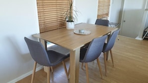 A dining table with four chairs, a potted plant, and a decorative plate.