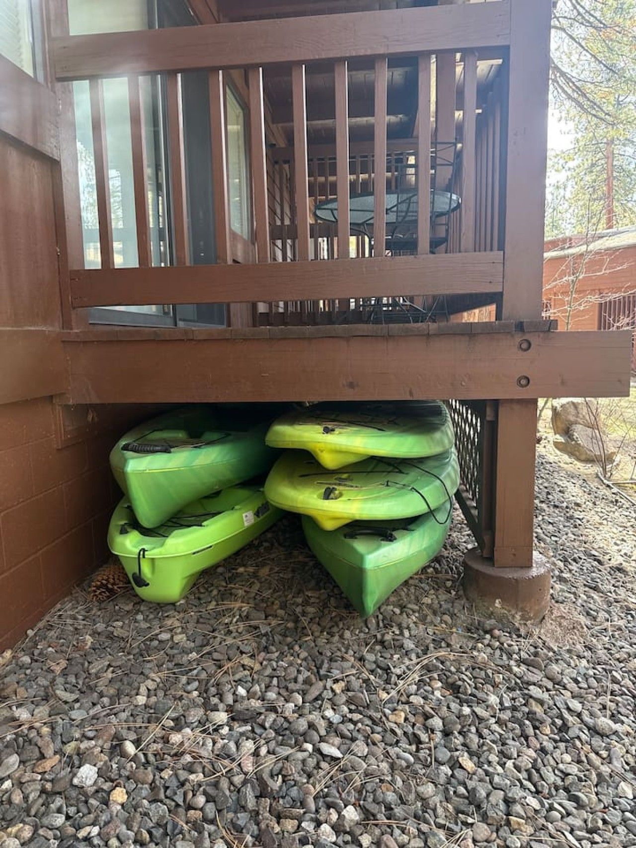 A wooden deck with kayaks stored underneath.