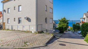 A multi-story building with a paved driveway and a view of the sea. - Holiday apartment with air conditioning and Internet access (Dramalj)