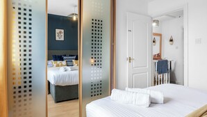 A hotel room with a bed, a wardrobe, and a bathroom.