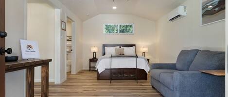 A bedroom with a bed, bedside tables, a ceiling fan, and a window.