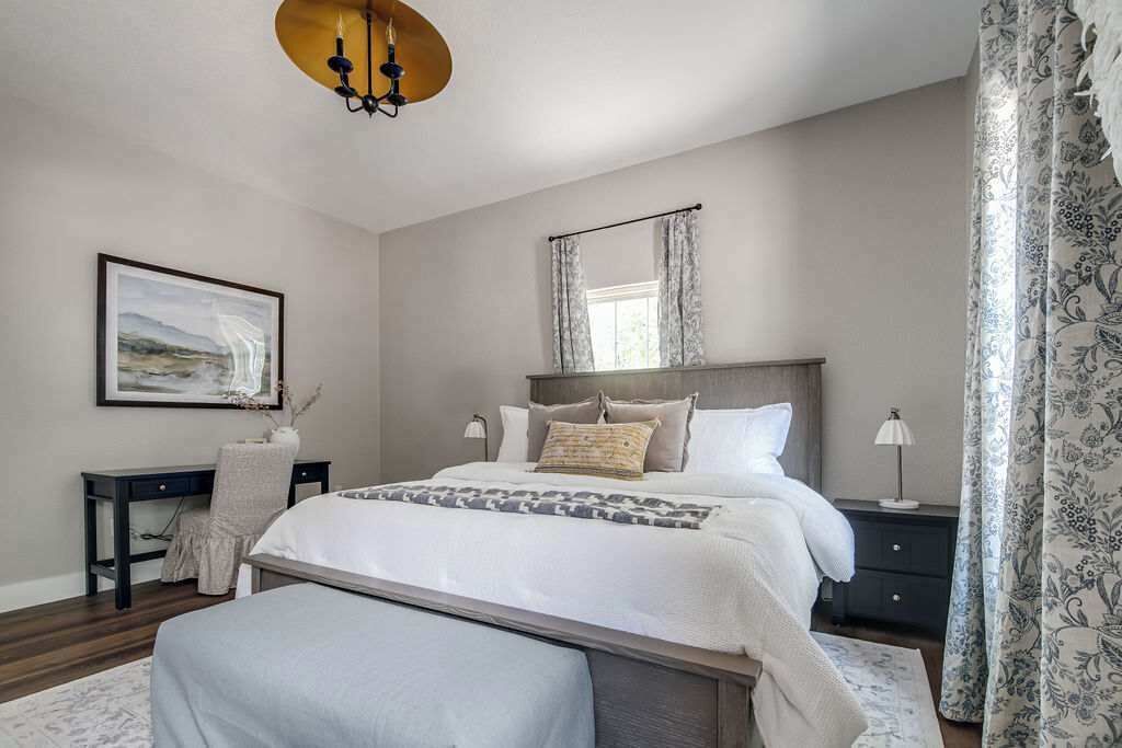 Une chambre à coucher avec un grand lit, des tables de chevet, un bureau et une chaise.