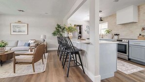 A modern kitchen with white cabinets, a built-in oven, and a countertop. - 108 Wisteria Dr (Fredericksburg)