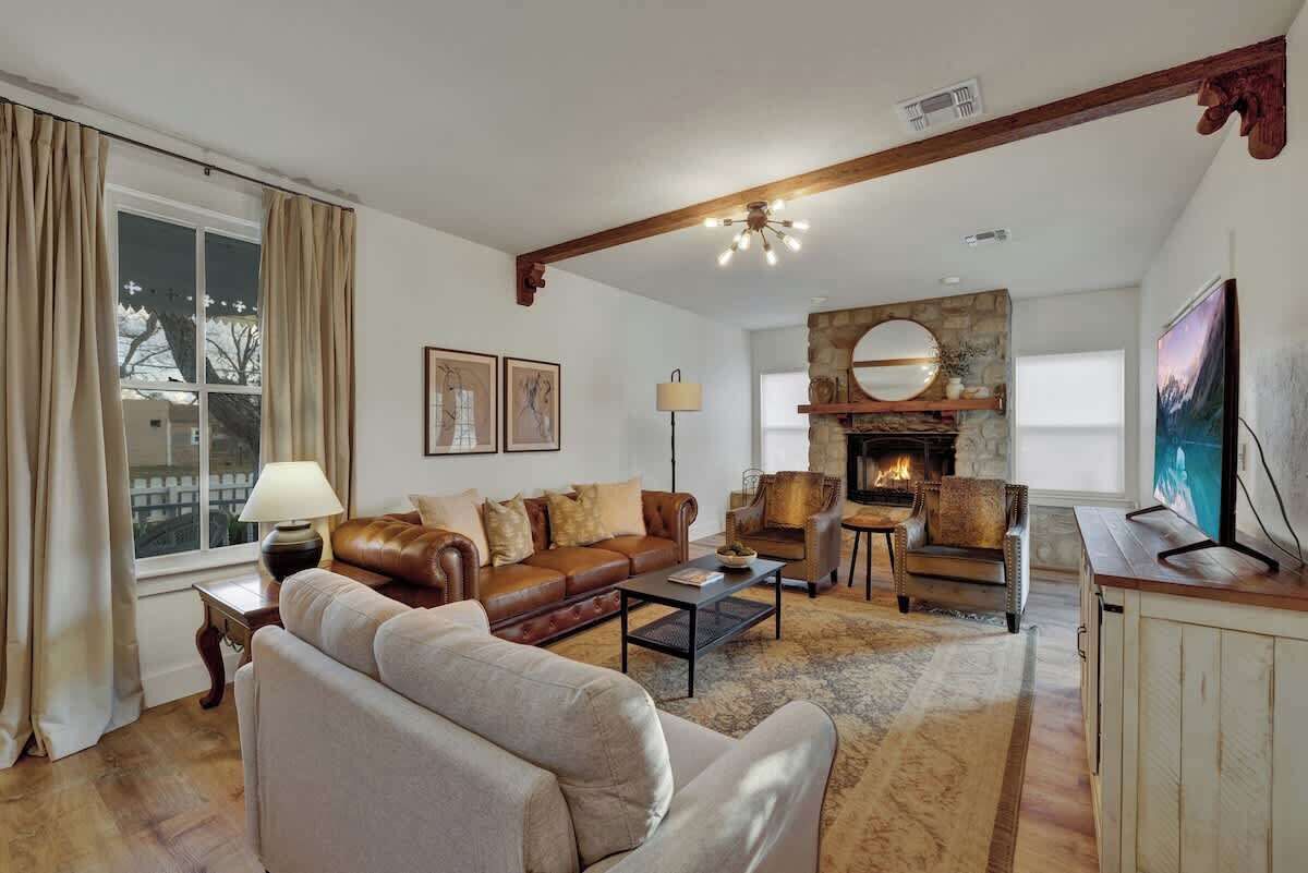 Una sala de estar acogedora con chimenea, sofá de cuero y una mesa de centro.