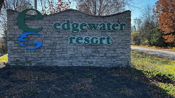 Een stenen bord met de tekst 'Edgewater Resort' en een gestileerd logo.