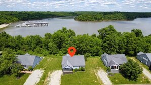 Luchtbeeld van een woongebied met huizen, een steiger en een rivier.