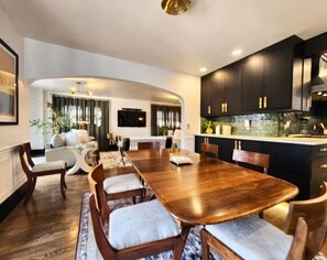 A modern kitchen with dark cabinets and a central island. - The Quad Haven & Loft (Casper)