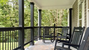 Un portico riparato con ringhiere in metallo nero e panche in legno.