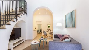 A modern living room with a staircase, a sofa, a coffee table, and a TV. - Dama Sicilian Luxury Home & SPA elegance and relaxation between Etna Catania and Taormina (Giarre)