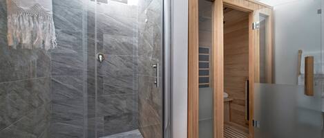 A modern bathroom with a glass-enclosed shower, a wooden sauna, and a marble-tiled floor.