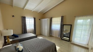 A hotel room with two beds, a large mirror, and a window with curtains.