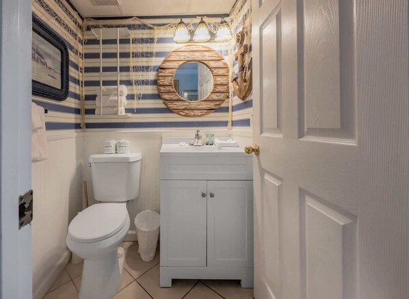 Un baño con inodoro, lavamanos y espejo.