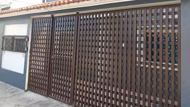 A residential building with a blue exterior, a gated entrance, and a tiled roof. - En la 96 (Cancún)
