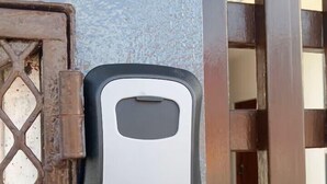 A door with a keypad lock and a metal gate. - En la 96 (Cancún)