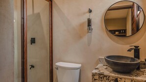 A bathroom with a toilet, a sink with a large basin, and a mirror on the wall. - JUNAB HOUSE - APARTMENT 4 (El Cuyo)