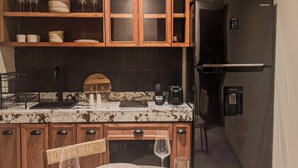 A kitchen with wooden cabinets, a Samsung refrigerator, and a dining table set with plates and glasses. - JUNAB HOUSE - APARTMENT 4 (El Cuyo)