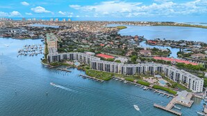 Un port de plaisance avec des bateaux, un grand bâtiment doté d’un toit rouge et, au loin, une vue sur la ville.