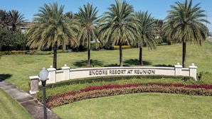 Naamplaatje voor Encore Resort at Reunion, met palmbomen en verzorgde gazons.