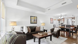 Una sala de estar moderna con un conjunto de sofá, una mesa de centro y un comedor con mesa y sillas.