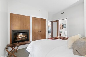 A bedroom with a fireplace, a bed, and a wardrobe.