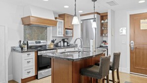 Una cocina moderna con una isla central, electrodomésticos de acero inoxidable y muebles de madera.