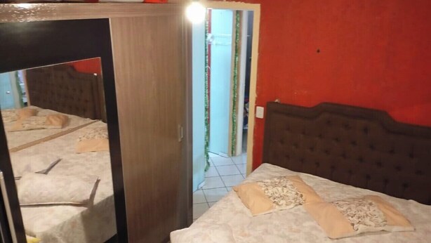 Una habitació amb un llit, un armari i un mirall.