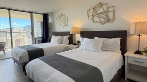 Ein Hotelzimmer mit zwei Betten, einem großen Fenster und moderner Einrichtung.