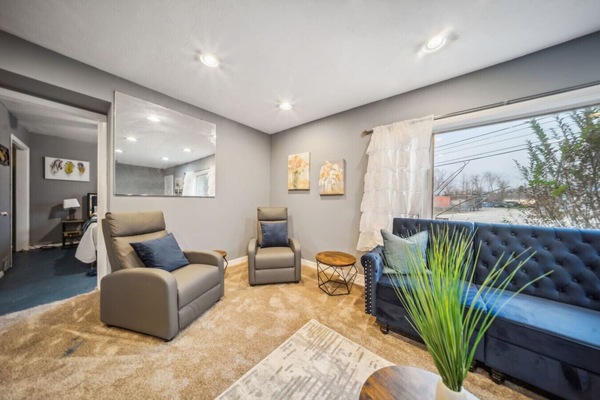 Relax and unwind in this stylish living area, featuring plush seating and a deep blue velvet sofa perfect for cozy evenings.