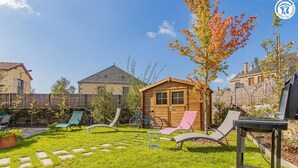 A backyard with a wooden shed, two lawn chairs, a grill, and a bicycle. - Le Saint-Loup - DRACY SAINT LOUP (DRACY SAINT LOUP)