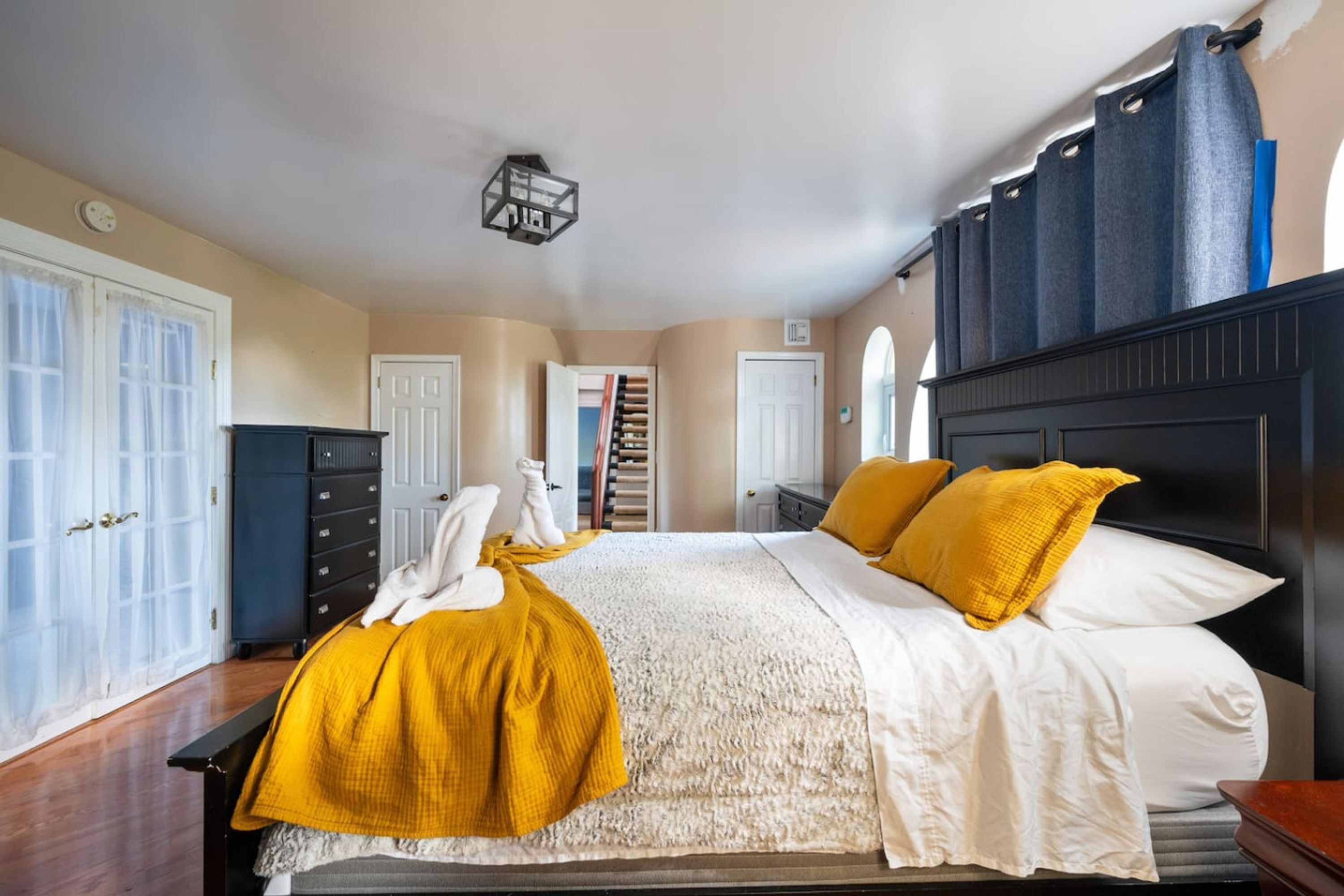 Ein Schlafzimmer mit Bett, Kleiderschrank, Nachttisch und Fenster.