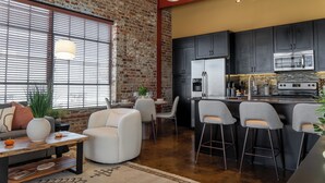 A modern kitchen with dark cabinets, a stainless steel refrigerator, and a built-in oven. - Free Garage + King Bed - Brick Loft in Downtown Roanoke - Walk to everything (Roanoke)
