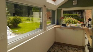 Une cuisine dotée d’une lucarne, d’une fenêtre et donnant sur un jardin.