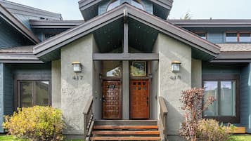 A modern house with a symmetrical facade, two doors labeled 417 and 416, and a small porch with steps.