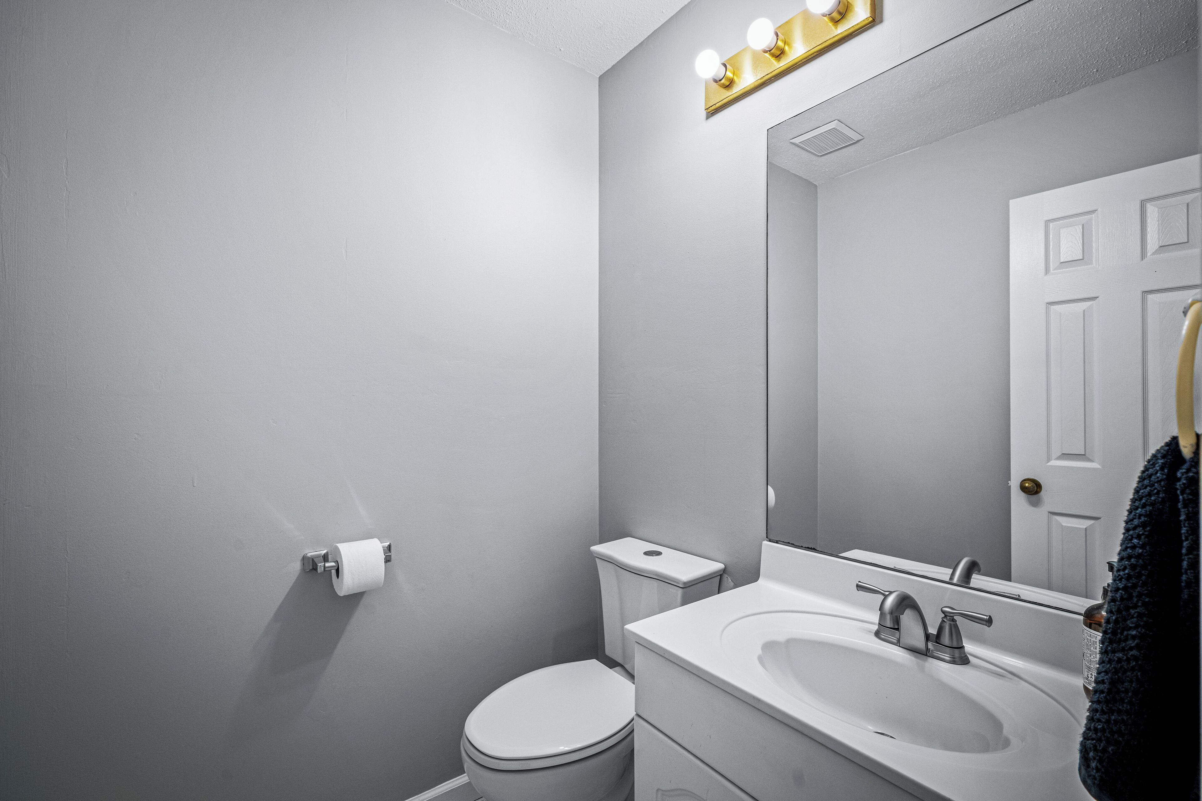 Ein Badezimmer mit Toilette, Waschbecken und Spiegel.