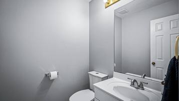 Ein Badezimmer mit Toilette, Waschbecken und Spiegel.