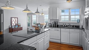A modern kitchen with white cabinetry, a granite countertop, and pendant lighting. - Best View Above Mentone - High Brow House - Elevate to Escape (Mentone)