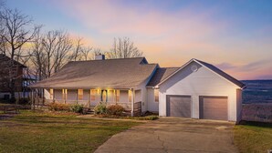 A two-story house with a covered porch and a garage. - Best View Above Mentone - High Brow House - Elevate to Escape (Mentone)
