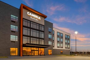 A modern hotel building with a prominent sign, large windows, and a covered entrance. - Cambria Hotel Euless - DFW Airport South (Euless)