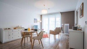Una sala de estar moderna y bien iluminada, con comedor, sofá y mesa de centro.