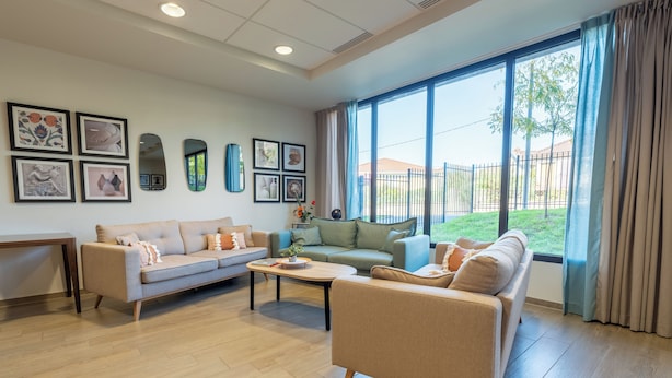 A spacious living room with two sofas, a coffee table, and a dining table. Large windows offer a view of the outdoors. - Quality Aparthotel Limoges (Limoges)