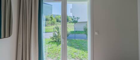 A room with a sliding glass door leading to a garden.