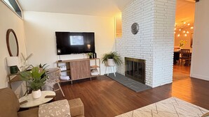 A modern living room with a fireplace, a flat-screen TV, and a cozy seating area. - Tulsa Expo Luxury Stay - 1 mi to Expo (Tulsa)