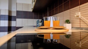 Eine moderne Küche mit einer glänzenden Arbeitsplatte, zwei Gläsern Orangensaft und einem Teller mit Keksen.