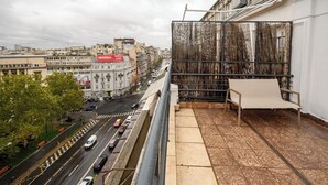 Ein Hochhaus mit einem Balkon mit Blick auf eine belebte Straße.